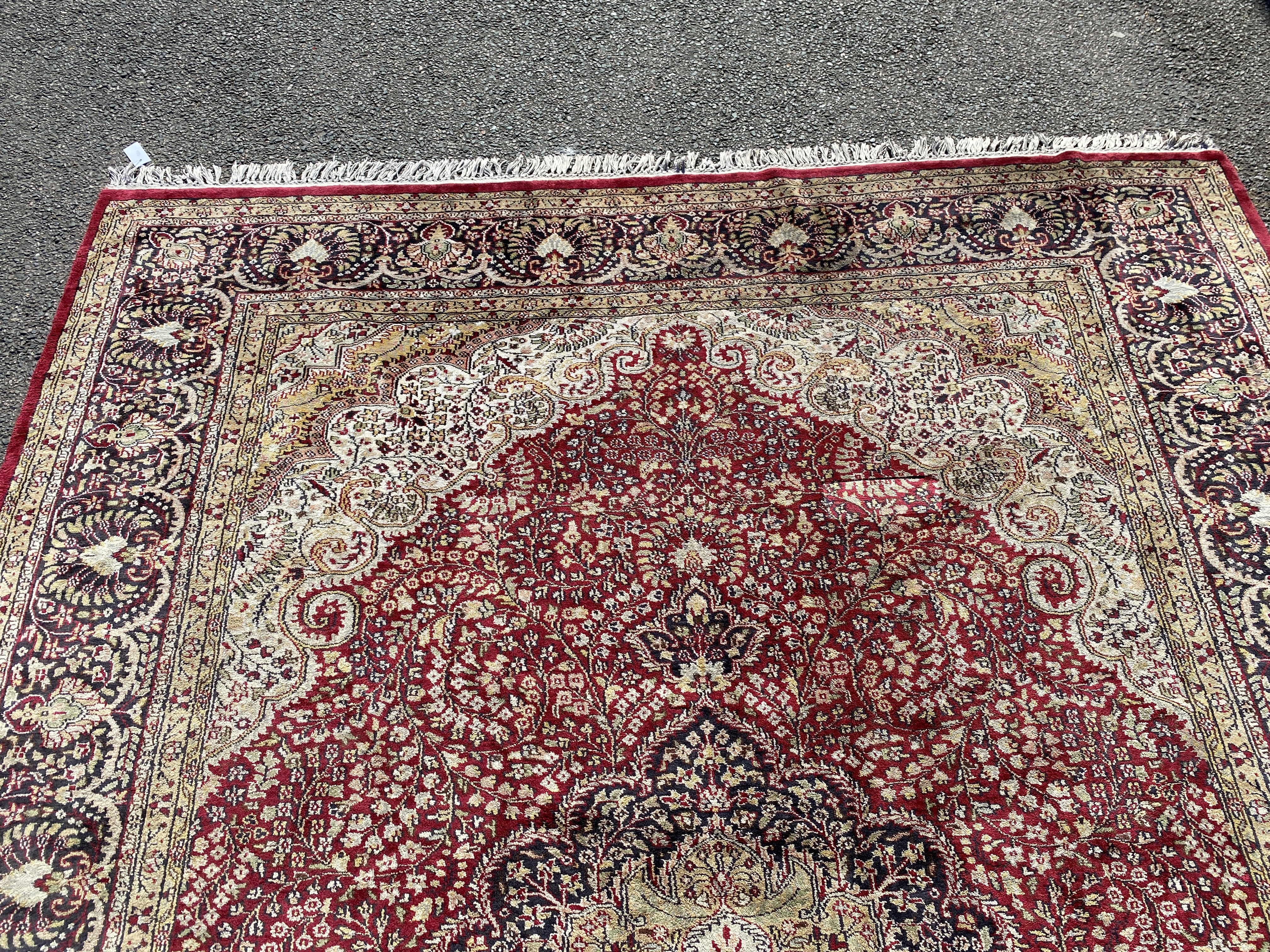 A Kashmiri part silk burgundy ground floral carpet, 330 x 240cm